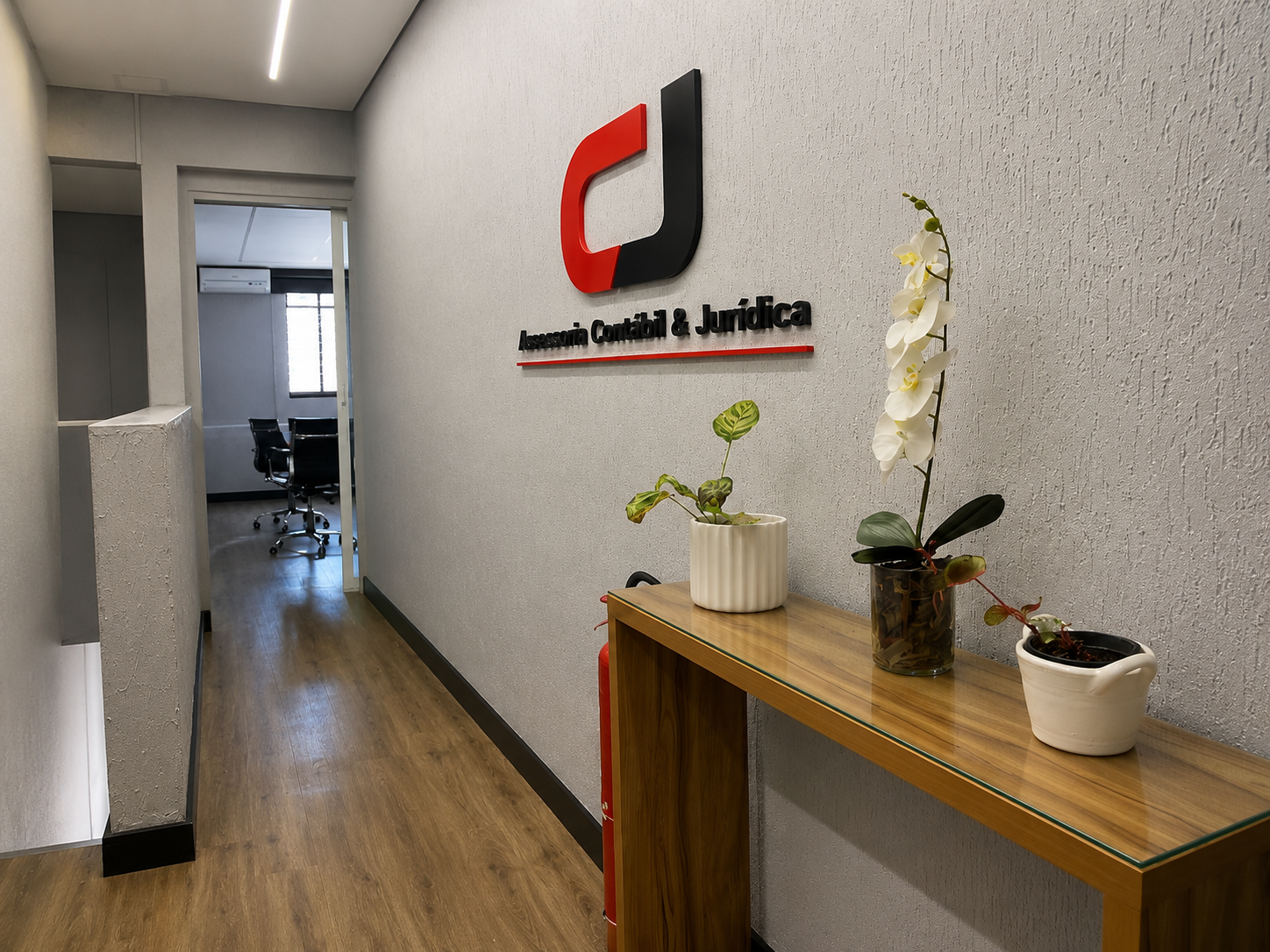 Corredor do escritório da CJ Assessoria Contábil e Jurídica, com a logo na parede